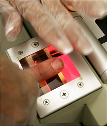 A man's fingerprints are electronically scanned at Utah's BCI. Not all states require checks of guard applicants. (Douglas C. Pizac, Associated Press)